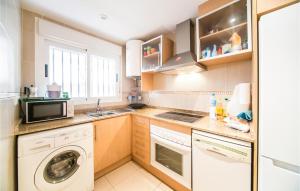a kitchen with a washing machine and a microwave at Gorgeous Apartment In Oropesa Del Mar in Oropesa del Mar