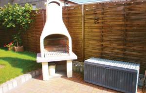 a pizza oven in a garden next to a fence at 1 Bedroom Stunning Apartment In Khlungsborn in Kühlungsborn