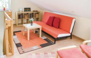 キュールングスボルンにあるStunning Apartment In Khlungsborn With 1 Bedrooms And Wifiのリビングルーム(オレンジ色のソファ、テーブル付)