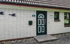 a white brick building with a black door and windows at 2 Bedroom Cozy Apartment In Dagebüll in Dagebüll