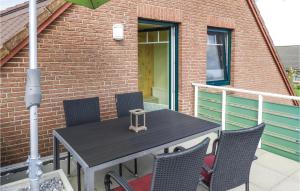 a table with chairs and an umbrella on a patio at 2 Bedroom Cozy Apartment In Dagebüll in Dagebüll