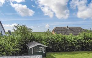 a small house in a yard next to some bushes at 2 Bedroom Cozy Apartment In Dagebüll in Dagebüll