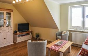 a living room with a table and a tv at 2 Bedroom Cozy Apartment In Dagebüll in Dagebüll +17 photos