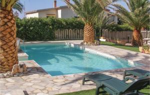 uma piscina com duas cadeiras e palmeiras em Casa Margherita 2 em Codaruina