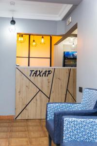 a room with a wall with a gate and two chairs at Hotel Tahar in Almaty