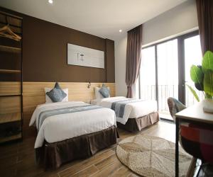 Habitación de hotel con 2 camas y ventana grande. en KingSales Hotel en Thanh Hóa
