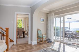 a bedroom with a sliding glass door leading to a dining room at Windy Heath in Salcombe