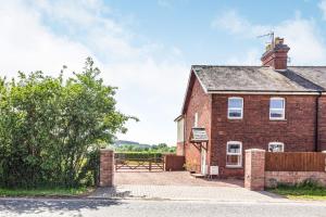 a brick house with a picnic table in front of it at 2 Stanley Villas in Hereford