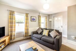 a living room with a couch and a tv at 2 Stanley Villas in Hereford