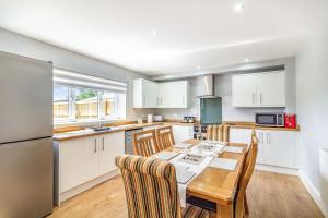 a kitchen with a table and chairs and a refrigerator at 2 Stanley Villas in Hereford