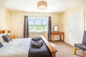 a bedroom with a bed and a window and a chair at 2 Stanley Villas in Hereford