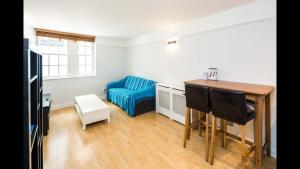 un soggiorno con tavolo e divano blu di Delightful 1-bedroom Apartment In Whitechapel a Londra