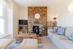 a living room with a couch and a fireplace at Bay View in Brixham