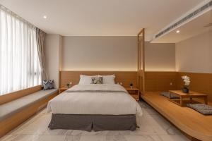 Un dormitorio con una cama grande y una ventana en Sun Moon Lake Apollo Resort Hotel en Yuchi
