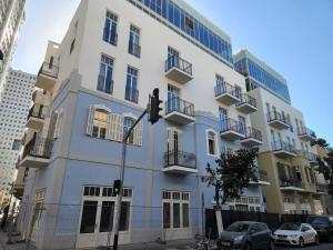 un edificio bianco con macchine parcheggiate di fronte di Alberto by Isrotel Design a Tel Aviv Altre 36 foto