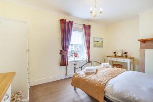 a bedroom with a bed and a window at Peth Head Cottage in Wooler