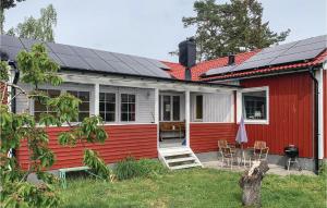 una casa rossa e bianca con pannelli solari di Amazing Home In Bromlla With 3 Bedrooms, Sauna And Wifi a Bromölla