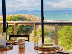 einen Tisch mit Meerblick von einer Veranda aus in der Unterkunft IdleWild - Secluded Absolute Beachfront Escape in Dolphin Sands