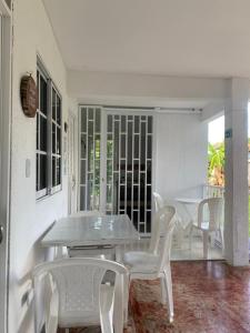 biała jadalnia ze stołem i białymi krzesłami w obiekcie Posada Gordon Antonio w mieście San Andrés