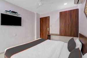 a bedroom with a bed and a flat screen tv at KUTCH HERITAGE HOTEL in Gandhidham