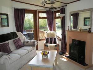 sala de estar con sofá y chimenea en Bend in the River Lodge en Stratford-upon-Avon