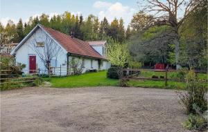 uma casa branca com uma porta vermelha e uma cerca em 3 Bedroom Amazing Apartment In stra Snnarslv em Östra Sönnarslöv