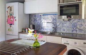 Östra Sönnarslöv的住宿－3 Bedroom Amazing Apartment In stra Snnarslv，厨房配有花瓶,桌子上放着鲜花