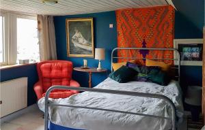 a bedroom with a bed and a red chair at Stunning Apartment In Östra Sönnarslöv in Östra Sönnarslöv