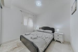 バールにあるApartmani Vittoriaの白いベッドルーム(ベッド1台、ナイトスタンド付)