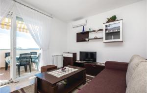 a living room with a couch and a tv at Beautiful Apartment In Smrika With Wifi in Šmrika