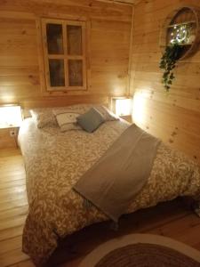 1 dormitorio con 1 cama en una habitación de madera en Chalet Boréal, en Pujaudran