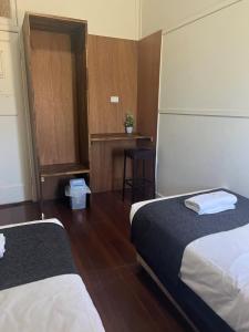 a hotel room with two beds and a table at Gin Gin Budget Accommodation in Gin Gin