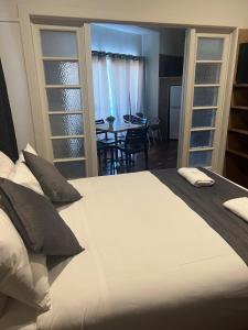 a bedroom with a large white bed and a dining room at Gin Gin Budget Accommodation in Gin Gin
