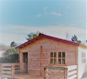 Cabaña de madera pequeña con techo rojo en Chalet Boréal, en Pujaudran
