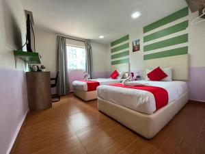 two beds in a room with green and white stripes at City Boutique Hotel - Bangi in Bangi