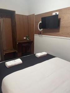 1 dormitorio con 1 cama y TV en la pared en Gin Gin Budget Accommodation en Gin Gin