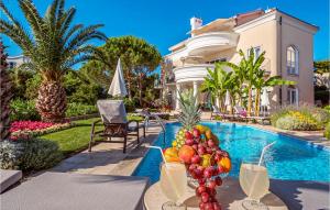 - une table avec des fruits et des boissons à côté de la piscine dans l'établissement Gorgeous Apartment In Malinska With Swimming Pool, à Malinska