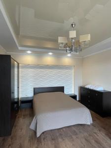 ein Schlafzimmer mit einem großen Bett und einem Fenster in der Unterkunft Затишні сучасні апартаменти в елітному ЖК Версаль in Truskawez