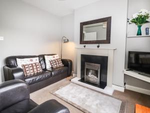 ein Wohnzimmer mit einem Sofa und einem Kamin in der Unterkunft Rydal View Cottage in Ambleside