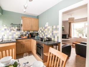 eine Küche mit Holzschränken und einer Arbeitsplatte in der Unterkunft Rydal View Cottage in Ambleside