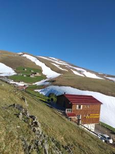 a building on the side of a hill with snow at MiGRORAŞ OTEL&RESTAURANT-KARESTER YAYLASI in Uzungöl