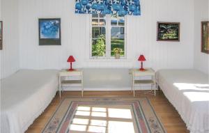 two beds in a room with two tables and a window at Three-Bedroom Holiday Home In Borrby in Borrby