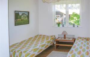 a bedroom with a bed and a table and a window at Three-Bedroom Holiday Home In Borrby in Borrby