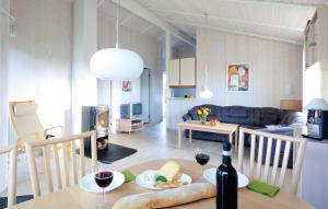 eine Küche und ein Wohnzimmer mit einem Tisch und einer Flasche Wein in der Unterkunft Strandpark 17 in Schönhagen