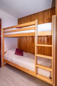 מיטה או מיטות קומותיים בחדר ב-appartement au pied des pistes