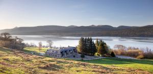an old house on a hill next to a lake at Bruce in Pitlochry