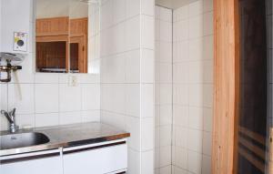 a kitchen with white tiled walls and a sink at Awesome Home In Visby With Sauna And Wifi in Visby
