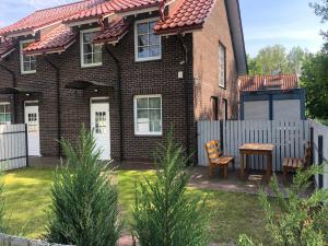 a house with a fence and a table in the yard at Karkle Seaside Apartments in Karklė