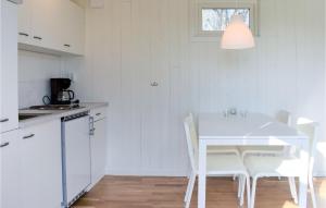 a white kitchen with a white table and chairs at Lovely Home In Hasslö With Kitchen in Hasslö