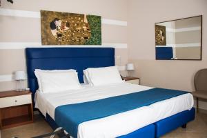 Una cama azul y blanca en una habitación de hotel en Albergo Ristorante del Cacciatore, en Foggia